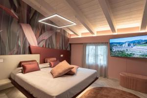 a bedroom with a bed and a flat screen tv at Il Giardino degli Angeli in Rivotorto