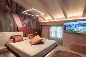 a bedroom with a bed and a flat screen tv at Il Giardino degli Angeli in Rivotorto 
