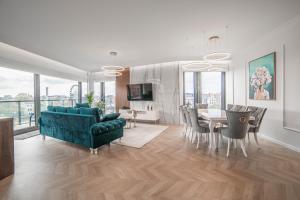 a living room with a green couch and a dining room at Apartament Amber Centrum Lux in Gdańsk
