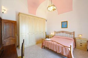プライアーノにあるVista Vetticaのベッドルーム1室(ピンクベッド1台、木製キャビネット付)