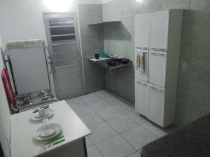 a small kitchen with a refrigerator and a sink at Piatto di Glória in Fortaleza