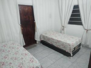a bedroom with two beds and a door and windows at Piatto di Glória in Fortaleza
