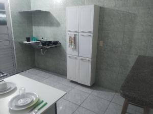 a kitchen with a white refrigerator and a sink at Piatto di Glória in Fortaleza