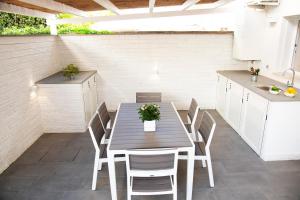 a table and chairs on a patio with a kitchen at Perla Vacanza in Santa Marinella