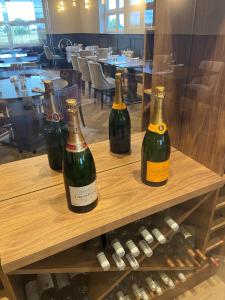 three bottles of wine sitting on a wooden shelf at Loftsome Bridge Hotel in Wressell