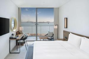 a hotel room with a bed and a view of the ocean at Radisson Beach Resort Palm Jumeirah in Dubai