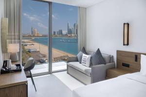a hotel room with a bed and a view of the ocean at Radisson Beach Resort Palm Jumeirah in Dubai