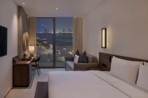 a hotel room with a bed and a large window at Radisson Beach Resort Palm Jumeirah in Dubai