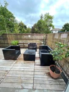 a patio with four black benches and a potted plant at Happy casita Disneyland Paris in Chalifert