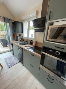 a kitchen with a stove top oven and a microwave at Happy casita Disneyland Paris in Chalifert