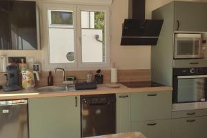 a kitchen with a sink and a stove top oven at Happy casita Disneyland Paris in Chalifert