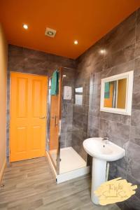 a bathroom with an orange door and a sink at Wild Savannah 1 Bedroom flat Petite Suites in Peterborough
