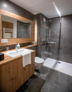 a bathroom with a sink and a toilet and a shower at Kolping-Hotel in Schweinfurt