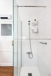 a bathroom with a shower with a glass door at Asunción Suite Apartment in Seville