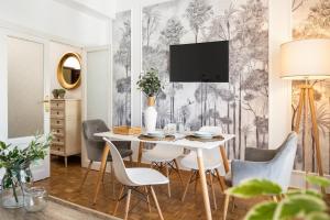 a dining room with a table with chairs and a tv at Asunción Suite Apartment in Seville