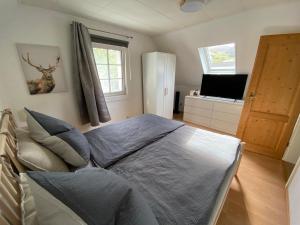 1 dormitorio con 1 cama y TV en Schmallenberger Ferienhaus, en Schmallenberg