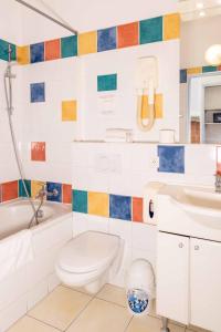 a bathroom with a toilet and a sink and a tub at Appartements Vivo in Cagnes-sur-Mer