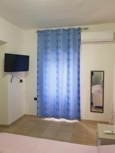 a room with a blue curtain and a bed at LA CASETTA DI MARY in Canosa Sannita