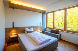 a bedroom with a large bed and two windows at Kolping-Hotel in Schweinfurt