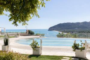 a view of a pool with the ocean in the background at Hotel Residence Il Porto in Mattinata