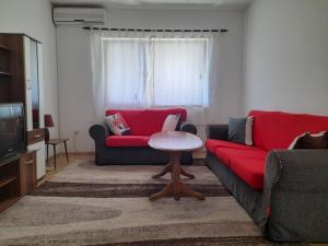 sala de estar con sofá rojo y mesa en Apartman Avdić, en Mostar