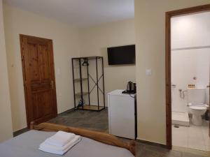 a room with a bathroom with a toilet and a television at Sun Touch Pelion Rooms in Kala Nera +56 photos