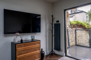 a living room with a flat screen tv on a wall at Honeysuckle Lodge in Knaresborough