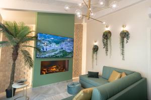 een woonkamer met een bank en een tv bij Il Giardino degli Angeli in Rivotorto 