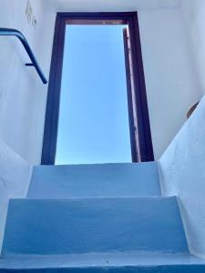 niebieska rampa z drzwiami na górze w obiekcie Ariadne's Rooms w mieście Apérathos