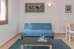 Sofá azul en la sala de estar con mesa en La Dimora Di Montelittu With AC - Happy Rentals, en Loiri