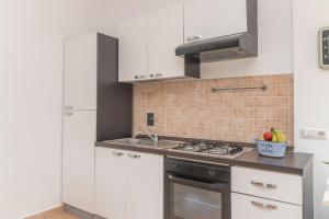 cocina con fregadero y fogones horno superior en La Dimora Di Montelittu With AC - Happy Rentals, en Loiri