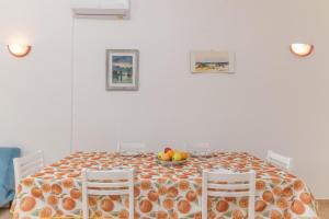 mesa de comedor con un bol de fruta y 2 sillas en La Dimora Di Montelittu With AC - Happy Rentals, en Loiri