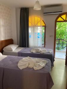 two beds in a room with towels on them at Sincer Otel in Kusadası