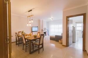 a dining room and living room with a table and chairs at Best Houses 66 - Côté Dune in Ferrel