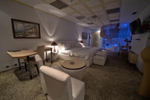 salon z łóżkiem, stołem i krzesłami w obiekcie Hotel Rosa Blu w Tiranie