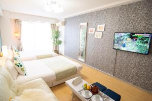 een hotelkamer met 2 bedden en een flatscreen-tv bij Nippombashi Art Hotel 705 in Osaka