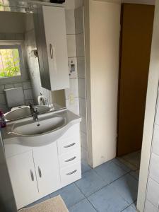 W łazience znajduje się umywalka i lustro. w obiekcie Palms Zimmer w mieście Frechen