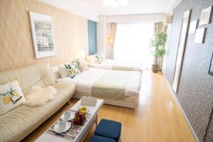 een woonkamer met een bed en een bank bij Nippombashi Art Hotel 705 in Osaka