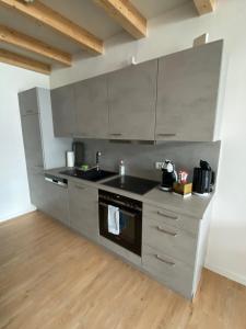 a kitchen with stainless steel appliances and wooden floors at Loft 53 in Goldkronach