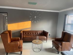 - un salon avec des canapés et une horloge murale dans l'établissement Mo'Acress Lifestyle, 