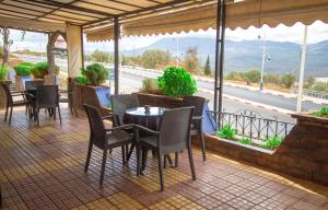 a patio with tables and chairs and a view of a highway at Hotel TOURAGHINE in Chefchaouene