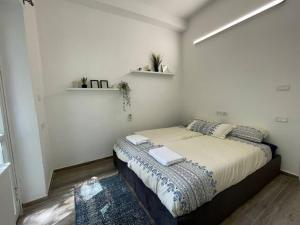 een slaapkamer met een bed met twee handdoeken erop bij Hillel 13 - city center in Jeruzalem