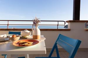 uma mesa com um prato de comida e um vaso em Hotel Residence Il Porto em Mattinata