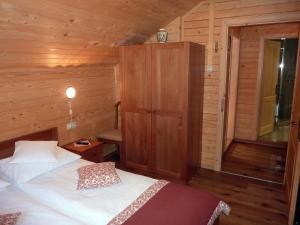 1 dormitorio con 1 cama en una cabaña de madera en Nagy Lak en Sub Cetate