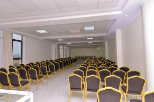 una stanza vuota con file di sedie e soffitti di GNS Hotel Kampala a Kampala
