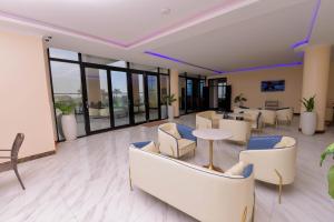una hall con sedie, tavoli e finestre di GNS Hotel Kampala a Kampala