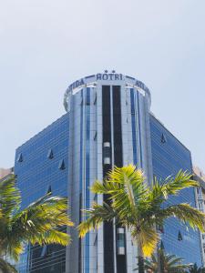 un edificio de hotel con palmeras delante en Silken Atlántida Santa Cruz en Santa Cruz de Tenerife