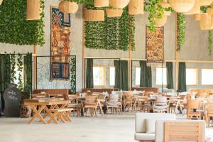 un restaurant avec des tables, des chaises et des plantes dans l'établissement Oasis212 Dakhla, à Dakhla