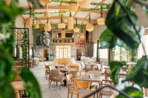 a dining room with tables and chairs and plants at Oasis212 Dakhla in Dakhla