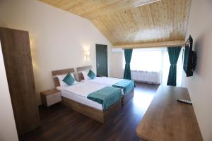 ein Schlafzimmer mit einem Bett und einem großen Fenster in der Unterkunft Maajid Quba Hotel&Restaurant Sanatorium in Quba